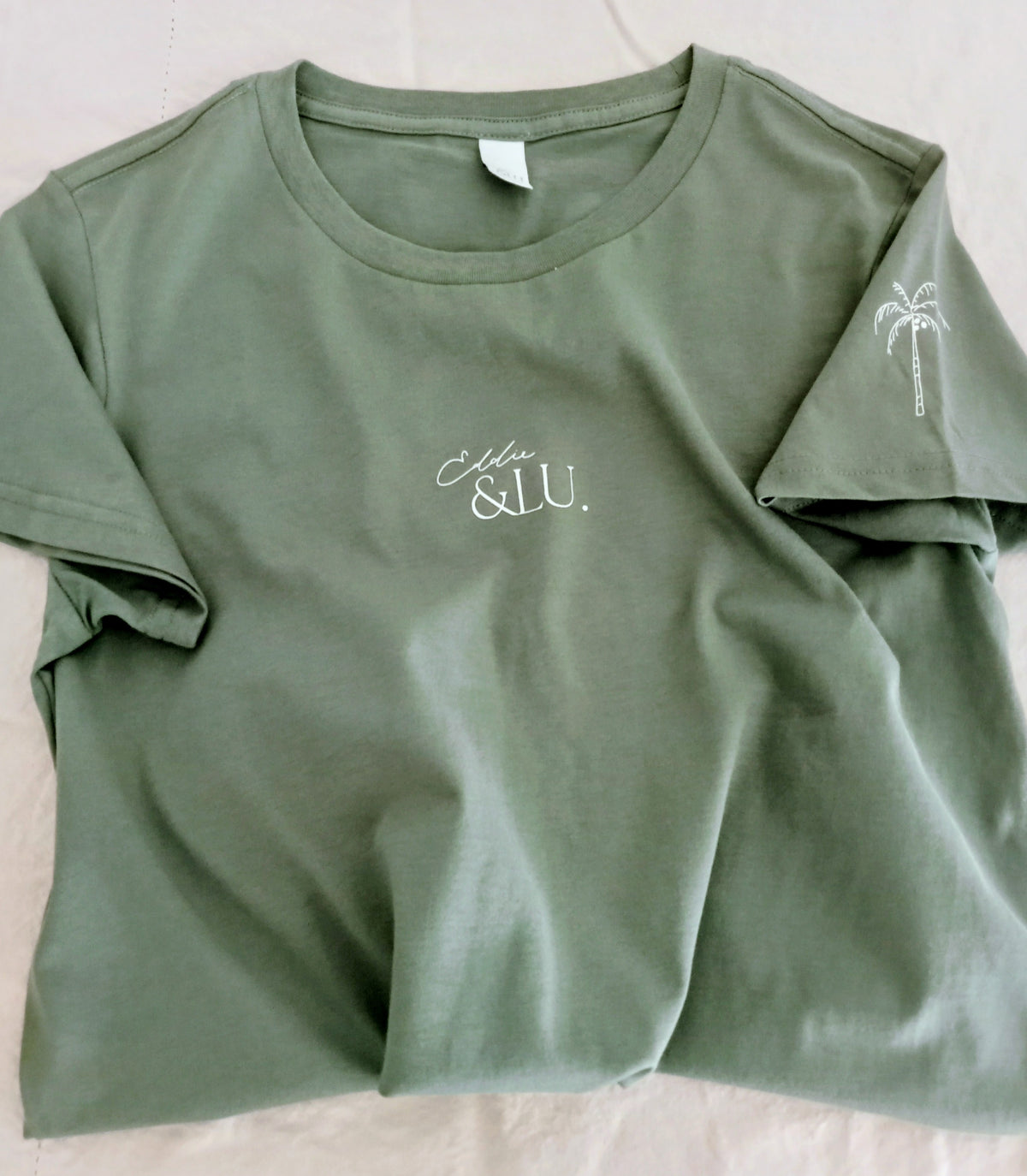 Green t-shirt with 'Ella & Lu' branding on a light background
