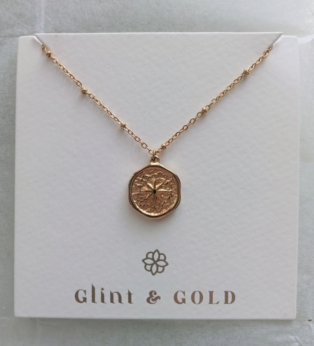 Rose gold necklace on a 'Glint & Gold' branded card