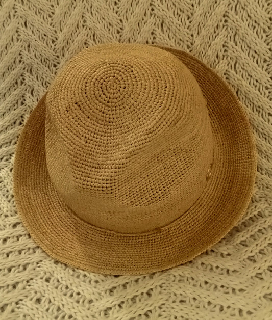 Brown raffia hat with cord on a textured beige rug.