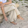 Woman wearing beige pants sitting on a rock with a natural background