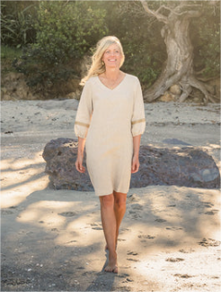 Model on beach wearing G&G Linen  Dress, V-neck, 3/4 sleeves, calf length, beige, with cuff trim
